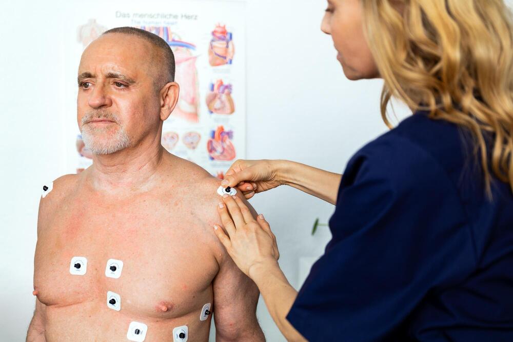Digital medicin teknik sjuksköterske sätter på EKG pads 